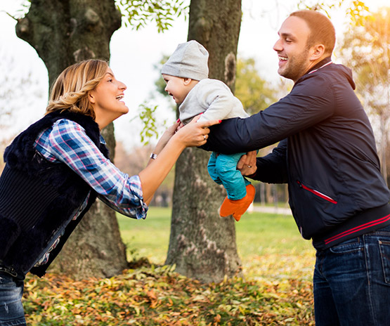 Young couple playing with child outside